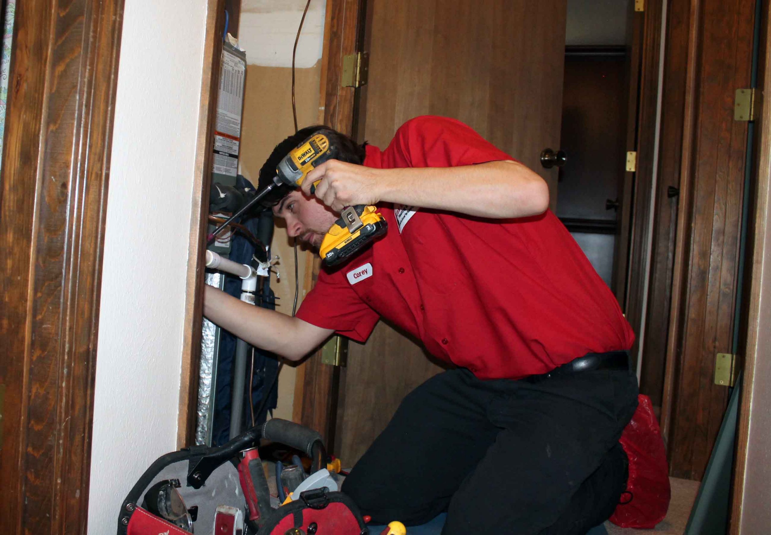 Jon Wayne Heating & Air tech repairing a furnace