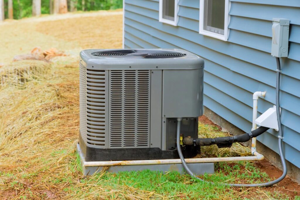 An outside air conditioner next to a house.