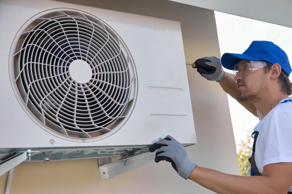 HVAC technician fixing an outdoor air conditioner.