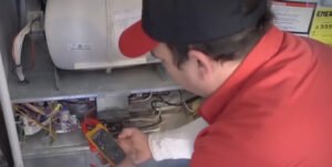 Jon Wayne Heating and Air technician diagnosing problems of a broken furnace
