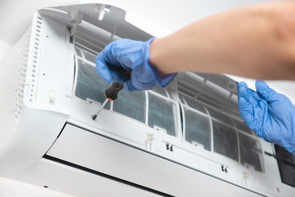 An HVAC technician installing a wall-mounted air conditioner
