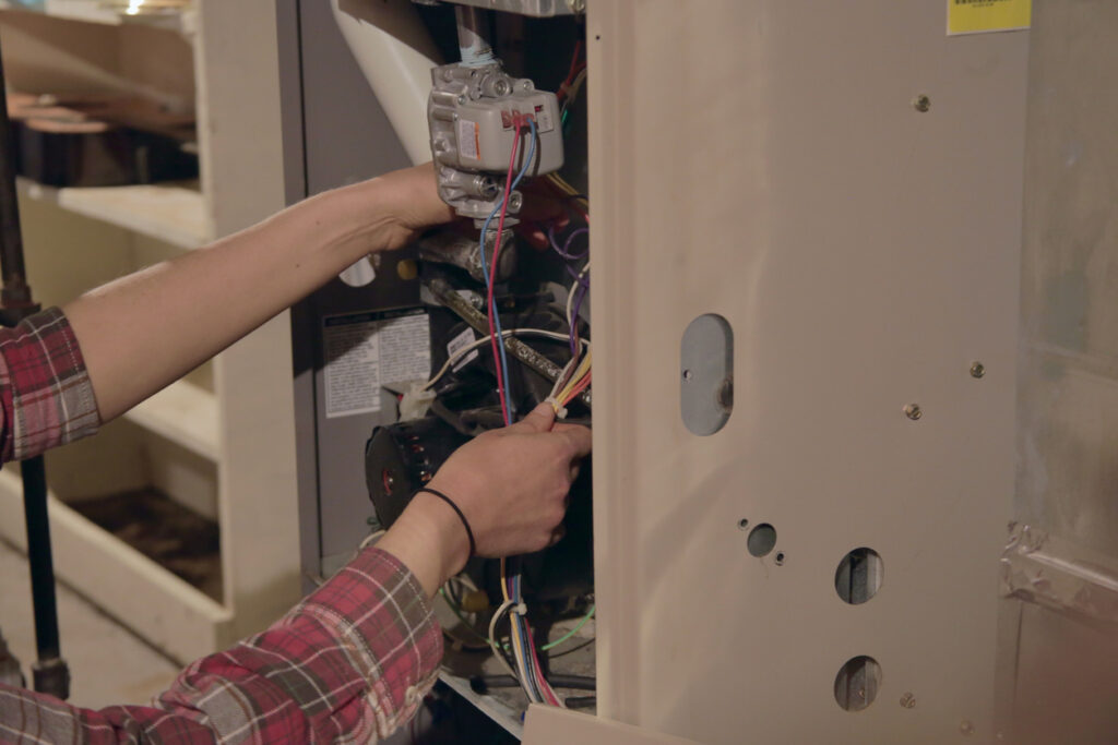 Hands working on an electric furnace